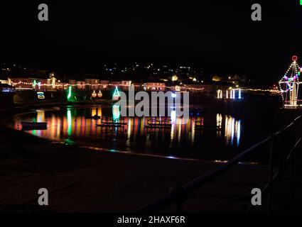 Mousehole,Cornouailles,15th décembre 2021, les gens visitent Mousehole pour voir les célèbres lumières de Noël dans les Cornouailles.À marée haute, les réflexions de lumière s'écouteront à travers le port.Il y a toutes les lumières traditionnelles de fête, y compris un chat et la souris.Credit: Keith Larby/Alamy Live News Banque D'Images