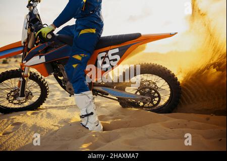 Motocross motocross rider roue de skidding soulevant la poussière de sable Banque D'Images