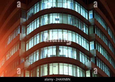 La façade d'un bâtiment en verre rond avec de grandes fenêtres panoramiques et des balcons la nuit, les fenêtres brillent dans l'obscurité.Dnipro City, Dnepr, Ukraine Banque D'Images