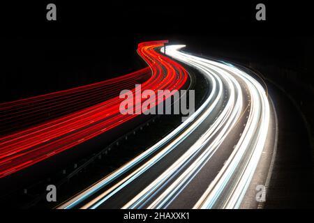 Route à plusieurs voies la nuit avec des sentiers légers d'une longue exposition, montrant le trafic en mouvement à l'heure de pointe.Route ou autoroute du Royaume-Uni, avec espace de copie Banque D'Images