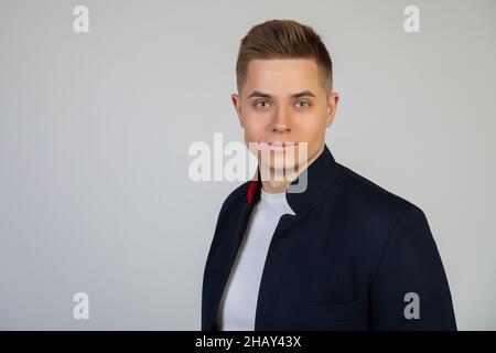 Beau jeune homme avec une coiffure élégante regardant l'appareil photo avec une expression sérieuse.Photo de jeune sympathique freelance moderne Banque D'Images