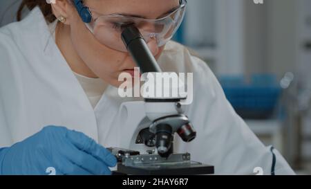 Scientifique regardant à travers la lentille microscopique pour travailler sur l'expérience, en utilisant le microscope pour analyser l'adn avec une focalisation sélective en laboratoire.Biologiste travaillant avec la loupe.Gros plan Banque D'Images