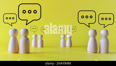 Concept de mêle, discussion, discussion.Poupées en bois avec bulle de discours sur fond jaune Banque D'Images
