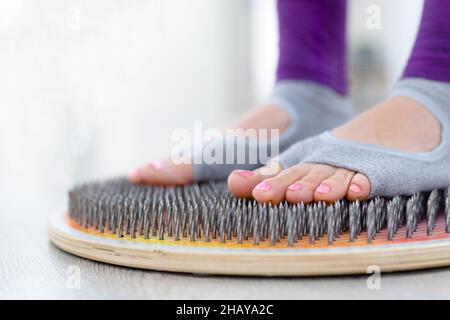 ands sur une planche à clous.Femme Yogi. Jambes gros plan.Pratique de yoga Banque D'Images