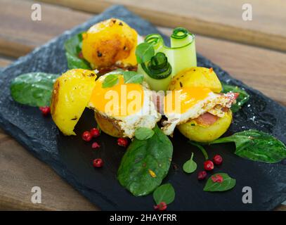 Gros plan des mini burgers des œufs de caille avec des pommes de terre cuites à l'assiette avec des légumes verts Banque D'Images