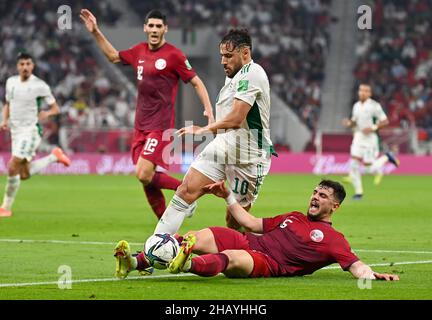 Doha, Qatar.15th décembre 2021.Mohammed Belaili (C) d'Algérie rivalise avec Bassam Hisham du Qatar lors de la coupe arabe de la FIFA Qatar 2021 demi-match entre le Qatar et l'Algérie au stade Al Thumama à Doha, Qatar, le 15 décembre 2021.Credit: Nikku/Xinhua/Alay Live News Banque D'Images