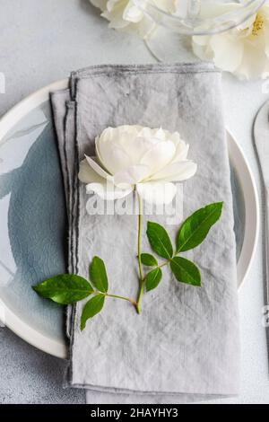 Rose blanche sur une serviette pliée sur une assiette Banque D'Images