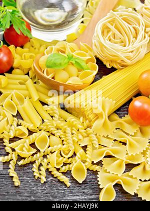 Pâtes à coque en cuillère, truquage de tuyaux, spaghetti, tagliatelles, fusilli,penne, farfalle, trenette, rotini, tomates,ail, huile végétale en carafe Banque D'Images