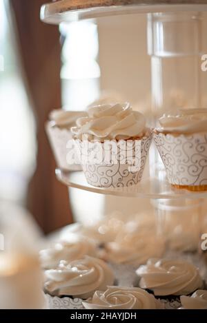 cupcakes vanille dans des tasses en dentelle blanche sur la tour à gâteau Banque D'Images