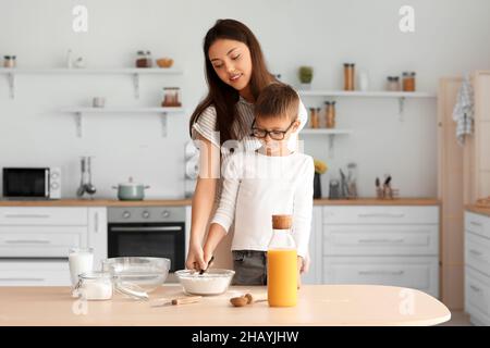 Une adolescente et son petit frère préparent de la pâte dans la cuisine Banque D'Images