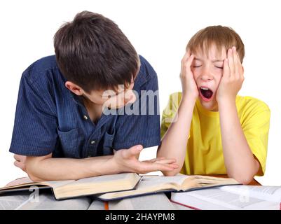 Frère aîné et enfant d'Annoyed sur le bureau d'école sur fond blanc Banque D'Images