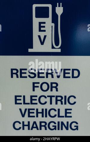 Véhicule électrique uniquement, panneau de stationnement réservé.Emplacement réservé pour le parking avec mot de peinture « chargement du véhicule électrique ». Banque D'Images