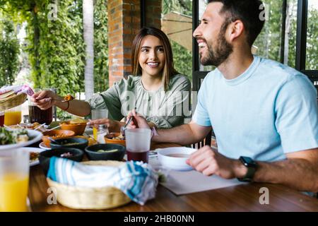 Couple hispanique mangeant des tacos et de la cuisine mexicaine sur la terrasse du restaurant en plein air au Mexique en Amérique latine Banque D'Images