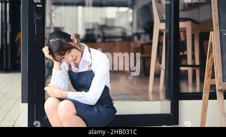 Stressé entrepreneur de petite entreprise assis devant son café. Banque D'Images