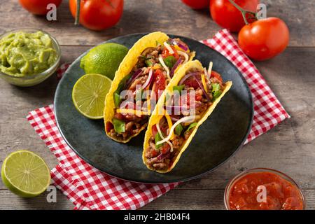 Tacos mexicains traditionnels avec viande et légumes sur une table en bois Banque D'Images