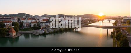 La rivière Drava s'écoulant sous les ponts de la ville de Maribor avec le soleil levant en arrière-plan Banque D'Images