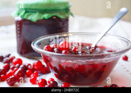 Dans un bol de confiture, de petits fruits et un pot de confiture sur une nappe blanche Banque D'Images