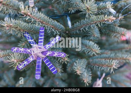 Décoration faite à la main sur un arbre de Noël extérieur fait de bâtons de glace artisanal en bois.Idées de bricolage pour les enfants.Environnement, recyclage et zéro déchet concept.Mise au point sélective. Banque D'Images