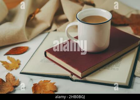 Livres et tasse de café avec feuilles d'automne.Mise au point sélective Banque D'Images