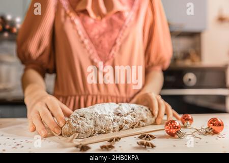Caucasienne fille en robe de fête préparée traditionnelle allemande de vacances Stollen cupcake.La veille de Noël maison atmosphère de vacances Banque D'Images