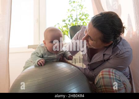 Mère et sa petite fille s'amusent avec le ballon de gymnastique. Banque D'Images