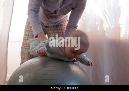 Mère et sa petite fille s'amusent avec le ballon de gymnastique. Banque D'Images