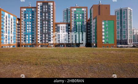 Vue aérienne de la ville résidentielle avec de nouveaux bâtiments modernes, colorés et élevés.Vidéo.Concept d'architecture, vol le long des nouvelles maisons et g Banque D'Images