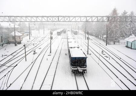 Gare avec chemins de fer couverts de neige en hiver.Wagons de fret avec charbon au premier plan.Ukraine, Europe Banque D'Images