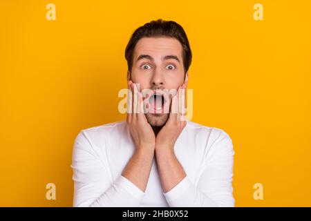 Photo du millénaire impressionné brunet Guy bouche ouverte porter chemise blanche isolée sur fond jaune vif Banque D'Images