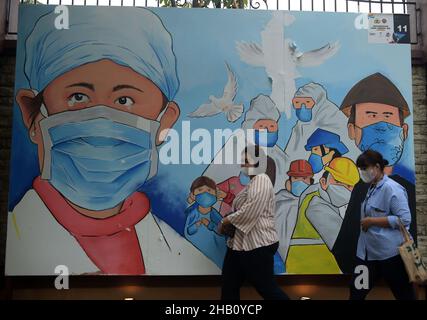 Jakarta, Indonésie.16th décembre 2021.Des gens marchent devant une fresque représentant des travailleurs de la santé qui luttent contre le COVID-19 à Jakarta, Indonésie, le 16 décembre 2021.L'Indonésie a détecté son premier cas de variante d'Omicron dans un employé du service de nettoyage dans un hôpital pour les patients de COVID-19 dans la capitale Jakarta, a déclaré jeudi le ministre de la Santé Budi Gunadi Sadikin.Credit: Zulkarnain/Xinhua/Alamy Live News Banque D'Images