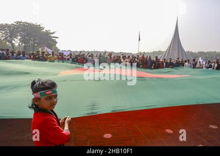 Les gens brandisent des drapeaux nationaux alors qu'ils se rassemblent pour rendre hommage au mémorial national des martyrs de la guerre d'indépendance de 1971 pour célébrer le jour de la victoire de 50th, qui marque la fin d'une guerre amère d'indépendance de neuf mois à Savar, le 16 décembre 2021.Le Bangladesh célèbre le 50th anniversaire de sa victoire nationale, en rappelant les vaillants combattants de la liberté qui ont combattu et fait le sacrifice ultime pour libérer le pays des forces pakistanaises.Les gens de tous les milieux ont commencé à se rassembler au Mémorial national du matin jeudi pour rendre leurs respects au m Banque D'Images