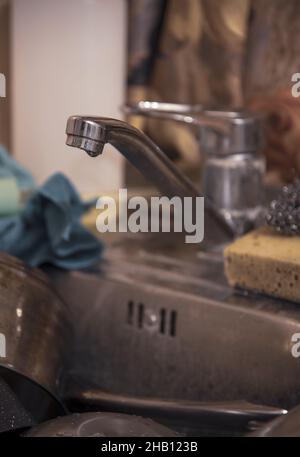 Le robinet d'eau sur l'évier de cuisine avec des plats sales.Concentrez-vous sur l'avant du robinet. Banque D'Images