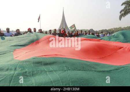 Les gens brandisent des drapeaux nationaux alors qu'ils se rassemblent pour rendre hommage au mémorial national des martyrs de la guerre d'indépendance de 1971 pour célébrer le jour de la victoire de 50th, qui marque la fin d'une guerre amère d'indépendance de neuf mois à Savar, le 16 décembre 2021.Le Bangladesh célèbre le 50th anniversaire de sa victoire nationale, en rappelant les vaillants combattants de la liberté qui ont combattu et fait le sacrifice ultime pour libérer le pays des forces pakistanaises.Les gens de tous les milieux ont commencé à se rassembler au Mémorial national du matin jeudi pour rendre leurs respects au m Banque D'Images