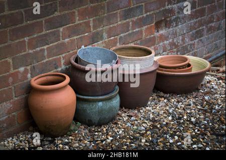 Vieux pots de jardin laissés à côté de vieux mur de jardin Banque D'Images