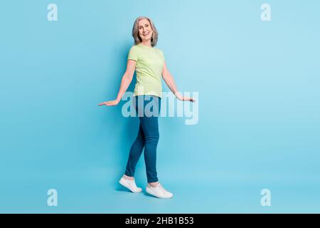 Pleine longueur corps photo senior entreprise femme marche vers l'avant gaie isolé pastel bleu couleur fond Banque D'Images