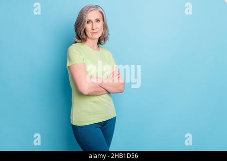Photo de sérieux confiant jolie charmante vieille femme tient les mains croisées isolées sur fond bleu pastel Banque D'Images