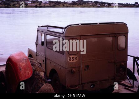 Série I 86 pouces Hard Top Land Rover avec « toit de safari », traversant le fleuve Zambèze, Zimbabwe Rhodésie, Afrique australe, années 1960 Banque D'Images