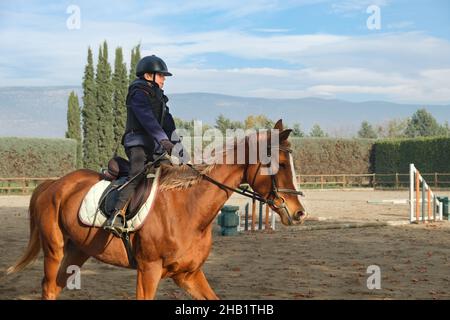 Enfant à cheval au ranch avec des obstacles et des barrières. Banque D'Images