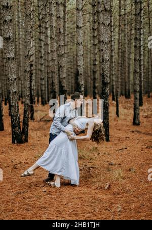 L'homme danse et plonge la femme en robe blanche dans la forêt de pins, Michigan Banque D'Images