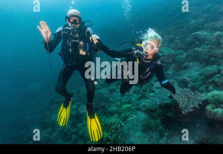 Un couple de plongée sous-marine explorant les eaux tropicales autour de Komodo Banque D'Images