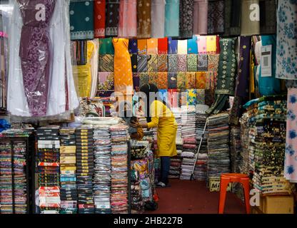 Kuala Lumpur, Malaisie.16th décembre 2021.Les employés des magasins de détail portant des masques de protection contre la propagation du Covid-19 vu à l'aide d'un téléphone mobile dans un magasin de Kuala Lumpur.(Photo de Wong Fok Loy/SOPA Images/Sipa USA) Credit: SIPA USA/Alay Live News Banque D'Images