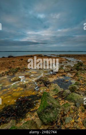 marée basse à la plage de gurnard sur la côte de l'île de wight, rive de l'île de wight solent à marée basse en regardant vers le continent à travers le solent. Banque D'Images