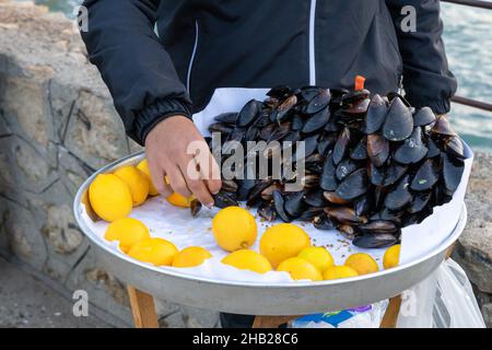 Moules farcies de style turc appelées sur le banc pour la vente avec un morceau de citron, CAN stock photo Midye dolma, moules farcies nourriture de mer turque. Banque D'Images