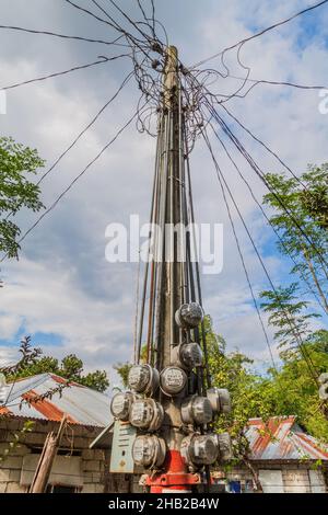 Compteur d'électricité sur un poteau dans le village de Santa Juliana, île de Luzon, Philippines. Banque D'Images