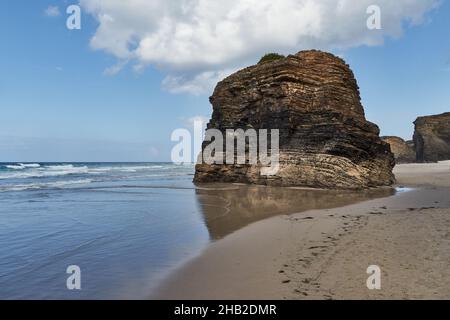 Un immense rocher produit par l'érosion de l'eau de pluie se trouve seul au milieu de la plage.Photographie horizontale.Copier l'espace. Banque D'Images