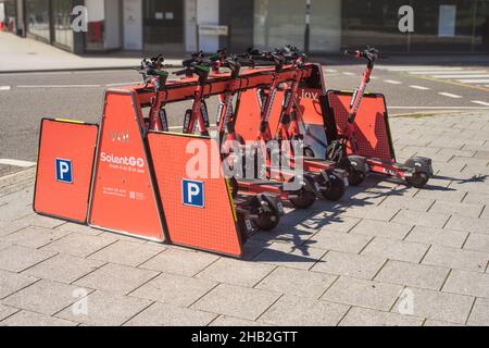 SolentGo VOI e-trottinettes garées dans un rack désigné dans le cadre de l'essai expérimental public de location de trottinettes électroniques à Southampton en 2021 Banque D'Images