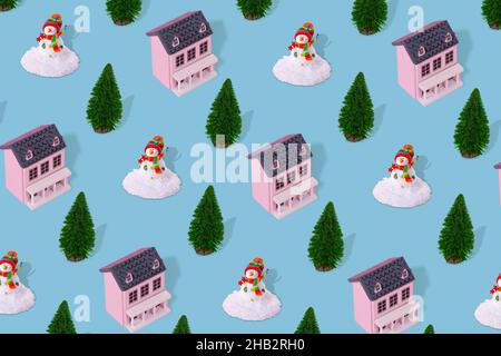 Paysage d'hiver suburbain concept de motif minimal avec maison rose, arbre de Noël et bonhomme de neige sur fond bleu pastel.Immobilier résidentiel, su Banque D'Images