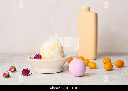 Composition avec bombes de bain, kumquat et fleurs de rose séchées sur fond clair Banque D'Images