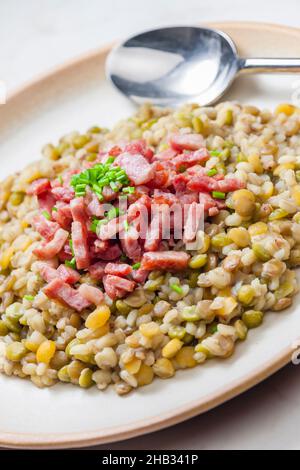 porridge de légumineuses avec bacon frit et ciboulette Banque D'Images