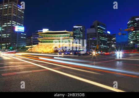 Porte de Namdaemun ou porte de Sungnyemun à l'heure bleue avec des pistes lumineuses des véhicules.Ce bâtiment historique est entouré de grands bâtiments modernes. Banque D'Images